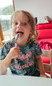 Dziecko z radością je miód z Pasieki Na Skarpie podczas rodzinnego posiłku.
