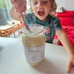 Uśmiechnięte dziecko jedzące naturalny miód z Pasieki Na Skarpie.