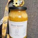 zdjęcie przedstawia brązowy medal wraz z miodem który zdobył to wyrónienie w międzynarodowym konkurskie Mead Madness Cup