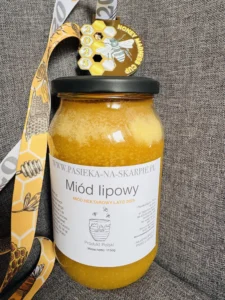 zdjęcie przedstawia brązowy medal wraz z miodem który zdobył to wyrónienie w międzynarodowym konkurskie Mead Madness Cup